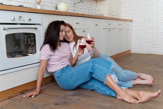 Hermosa pareja de lesbianas animando con unas copas de vino