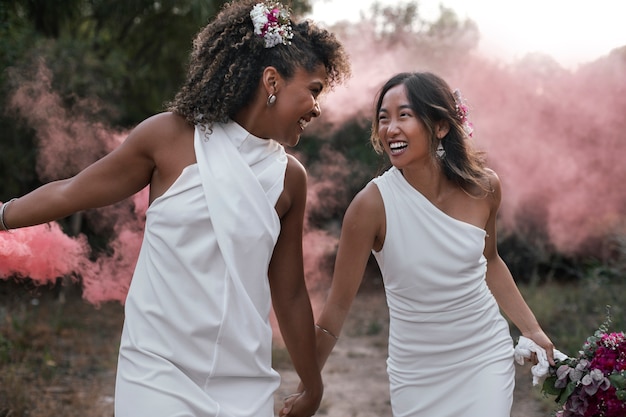 Una hermosa pareja de lesbianas celebrando su día de bodas al aire libre.