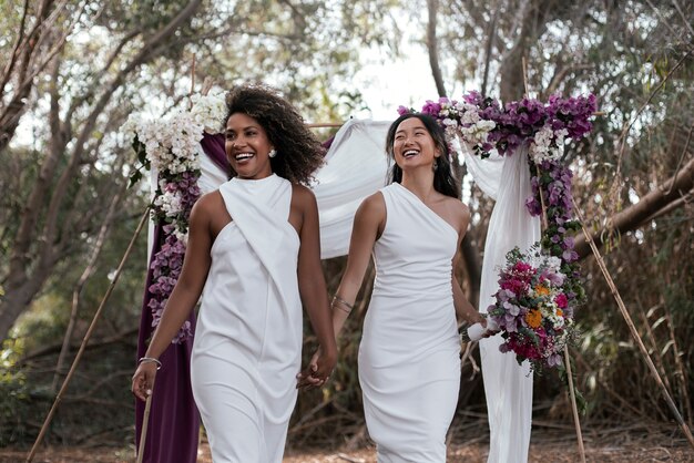 Una hermosa pareja de lesbianas celebrando su día de bodas al aire libre.