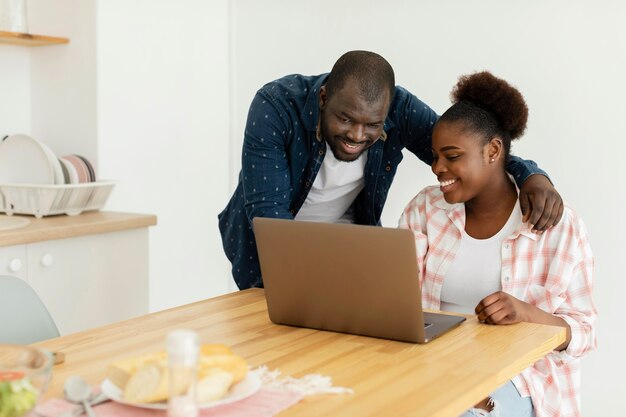 Hermosa pareja mirando su computadora portátil