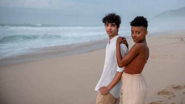 Foto gratuita hermosa pareja mostrando afecto en la playa cerca del océano