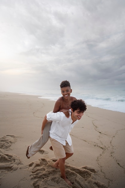 Foto gratuita hermosa pareja mostrando afecto en la playa cerca del océano