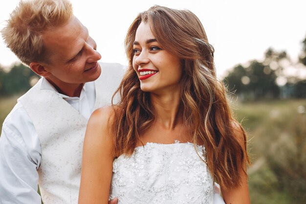 Hermosa pareja de novios en un campo de verano