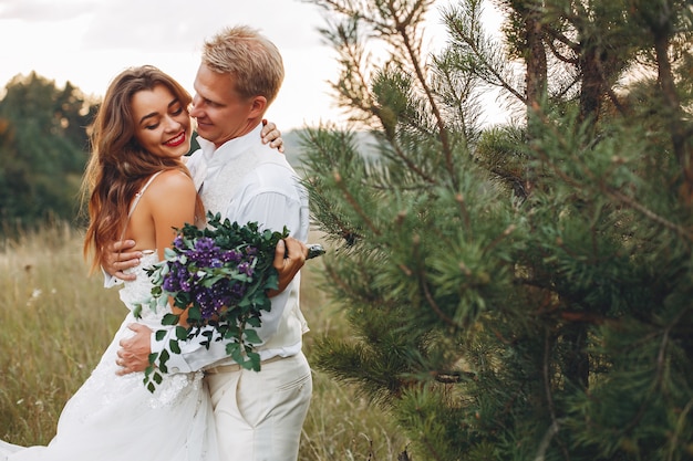 Hermosa pareja de novios en un campo de verano