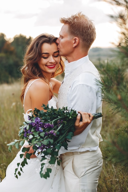 Hermosa pareja de novios en un campo de verano