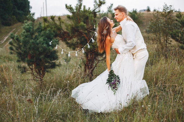 Hermosa pareja de novios en un campo de verano