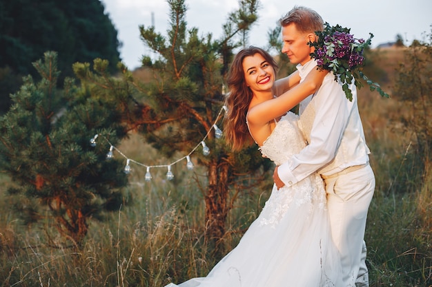 Hermosa pareja de novios en un campo de verano