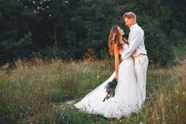 Hermosa pareja de novios en un campo de verano