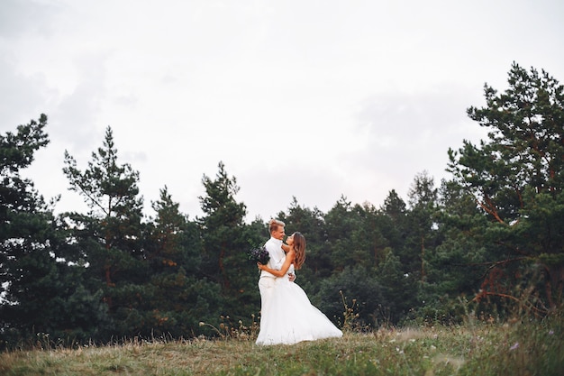 Hermosa pareja de novios en un campo de verano