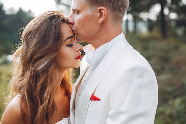 Hermosa pareja de novios en un campo de verano