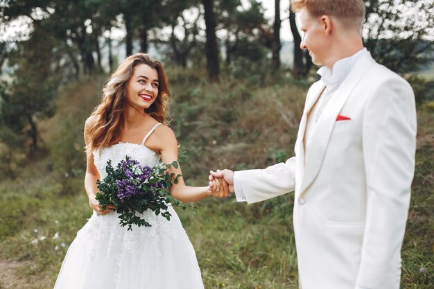 Hermosa pareja de novios en un campo de verano