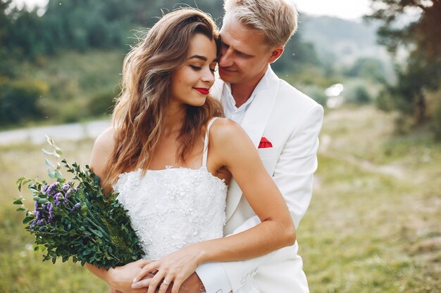 Hermosa pareja de novios en un campo de verano