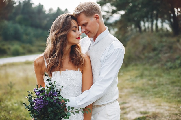 Hermosa pareja de novios en un campo de verano