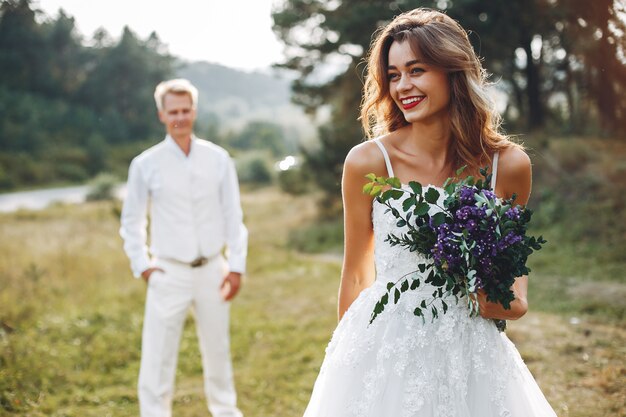 Hermosa pareja de novios en un campo de verano