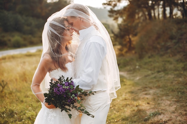 Hermosa pareja de novios en un campo de verano