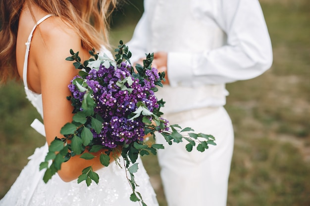 Hermosa pareja de novios en un campo de verano