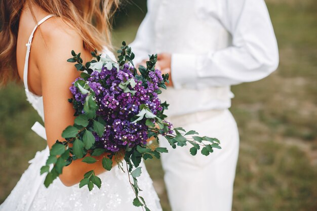 Hermosa pareja de novios en un campo de verano