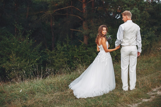 Hermosa pareja de novios en un campo de verano