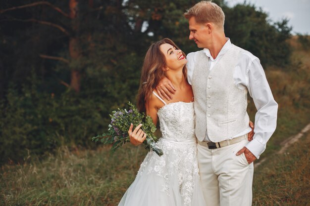 Hermosa pareja de novios en un campo de verano