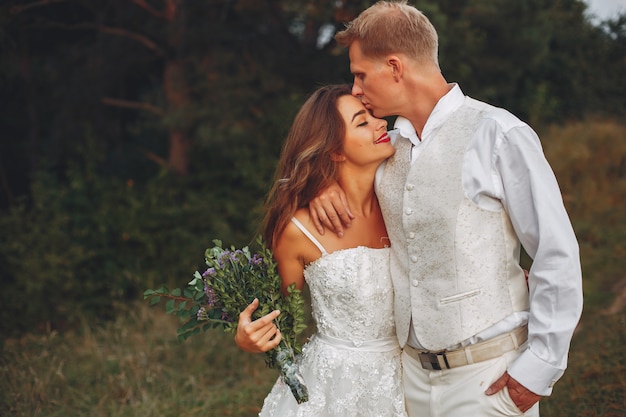 Hermosa pareja de novios en un campo de verano