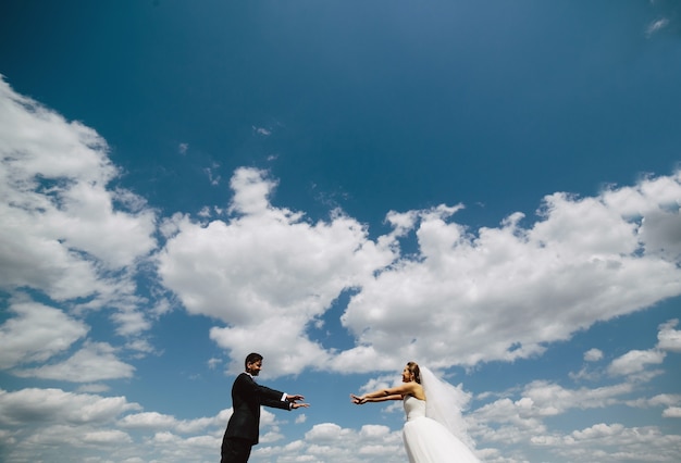 Hermosa pareja de novios en el fondo de cielo azul