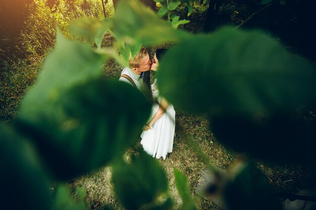 Hermosa pareja de novios posando en un bosque