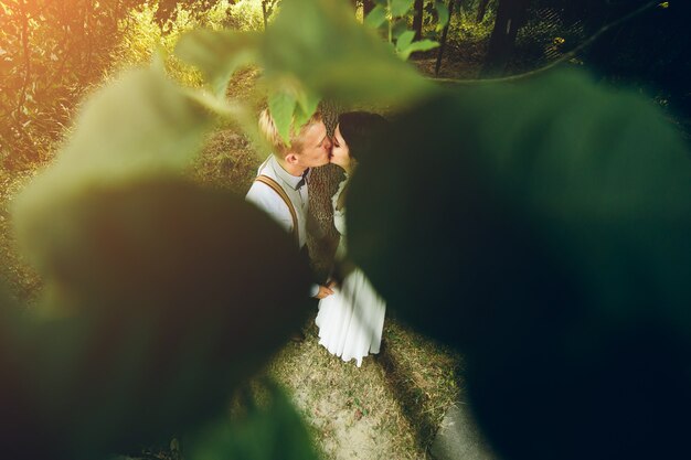 Hermosa pareja de novios posando en un bosque