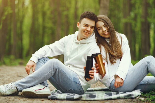 Hermosa pareja pasa tiempo en un bosque de primavera