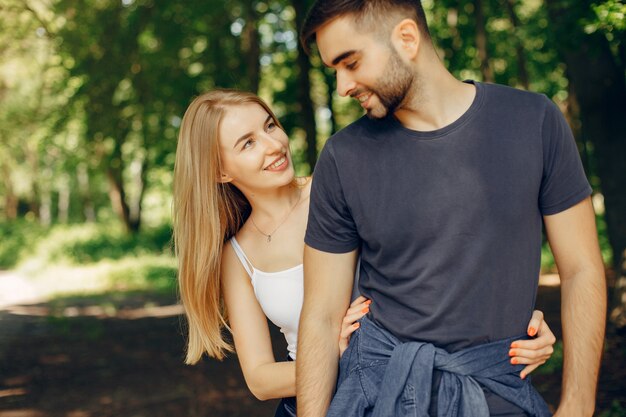 Hermosa pareja pasa tiempo en un bosque de verano