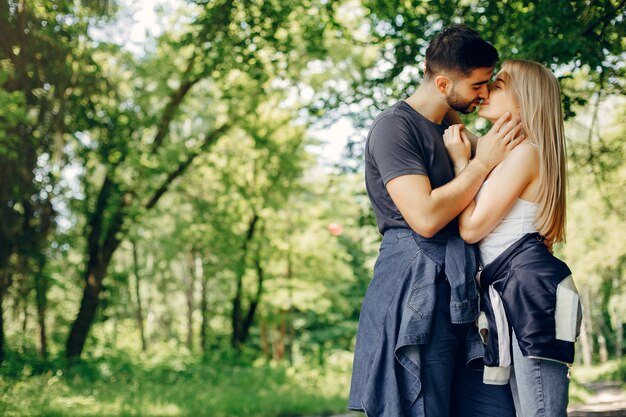 Hermosa pareja pasa tiempo en un bosque de verano