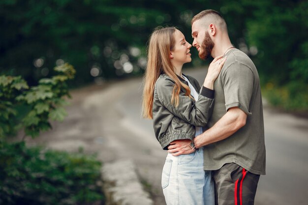 Hermosa pareja pasa tiempo en un bosque de verano