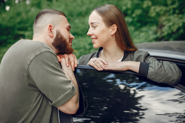 Hermosa pareja pasa tiempo en un bosque de verano