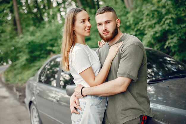 Hermosa pareja pasa tiempo en un bosque de verano