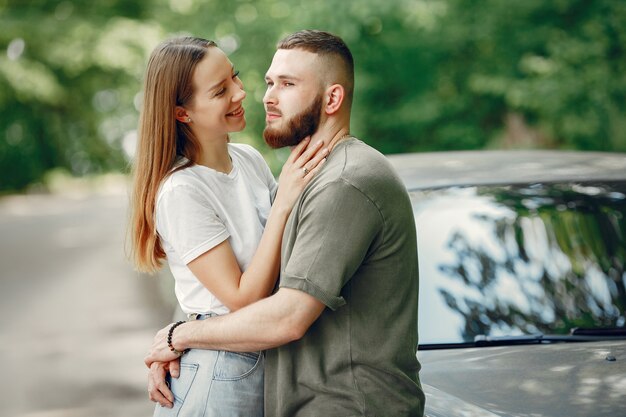 Hermosa pareja pasa tiempo en un bosque de verano