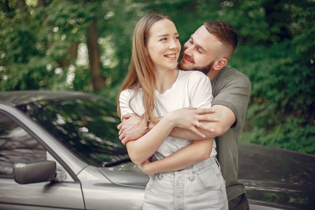 Hermosa pareja pasa tiempo en un bosque de verano