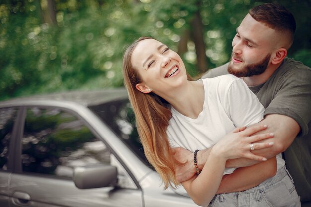 Hermosa pareja pasa tiempo en un bosque de verano