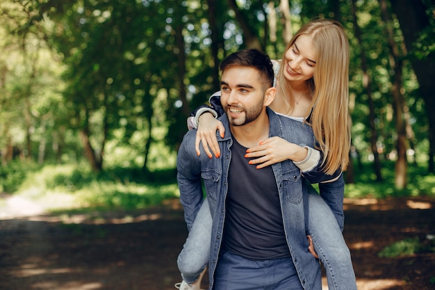 Hermosa pareja pasa tiempo en un bosque de verano