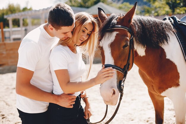 Hermosa pareja pasa tiempo con un caballo.