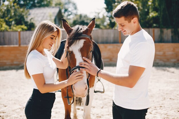 Hermosa pareja pasa tiempo con un caballo.