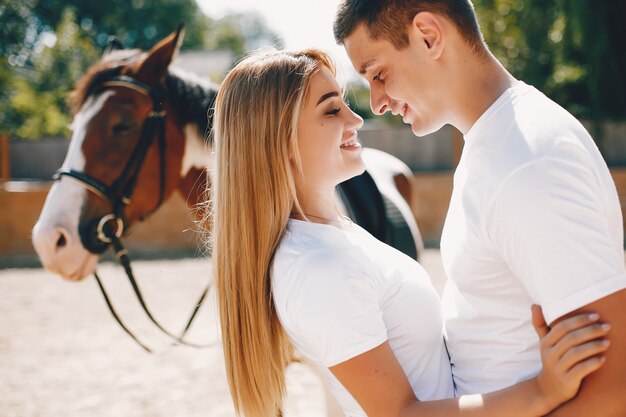 Hermosa pareja pasa tiempo con un caballo.