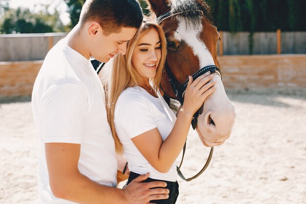 Hermosa pareja pasa tiempo con un caballo.