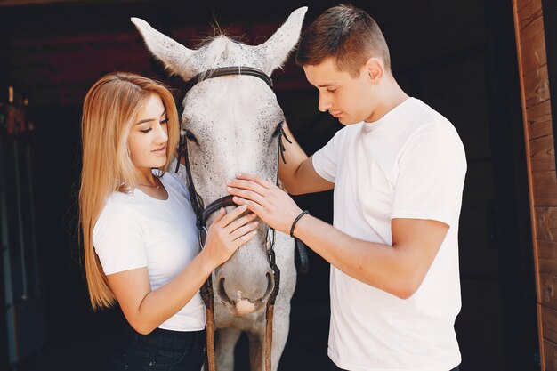 Hermosa pareja pasa tiempo con un caballo.