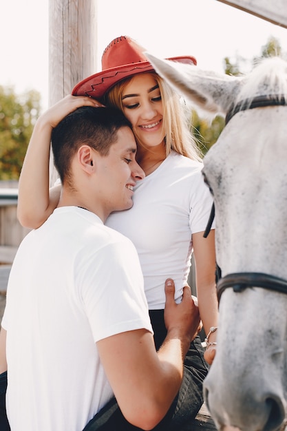 Foto gratuita hermosa pareja pasa tiempo con un caballo.