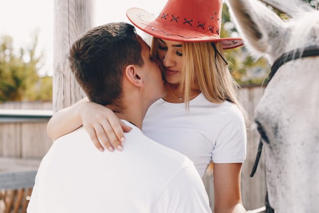 Hermosa pareja pasa tiempo con un caballo.