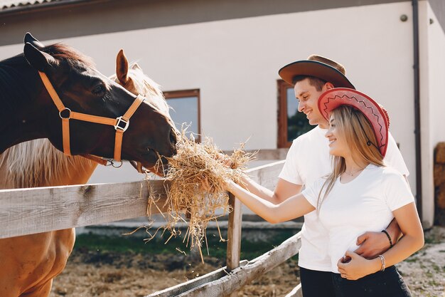 Hermosa pareja pasa tiempo con un caballo.