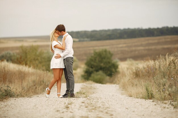 Hermosa pareja pasa tiempo en un campo de otoño