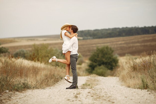 Hermosa pareja pasa tiempo en un campo de otoño