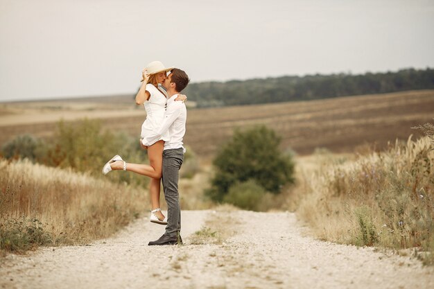 Hermosa pareja pasa tiempo en un campo de otoño