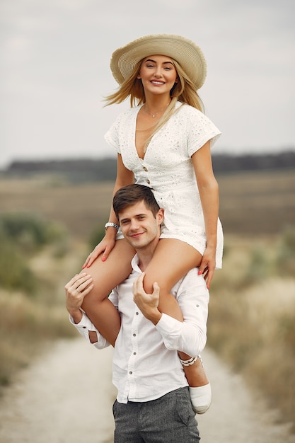 Hermosa pareja pasa tiempo en un campo de otoño