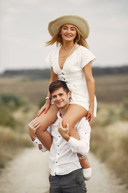 Hermosa pareja pasa tiempo en un campo de otoño